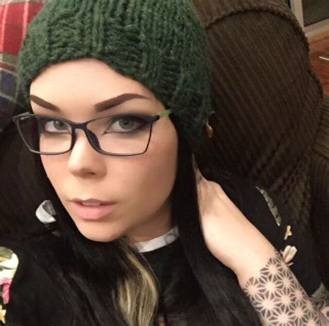 A Woman Wearing Glasses And A Green Knitted Hat