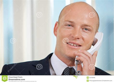 Portrait Of Businessman Talking On Telephone At Office Stock Image