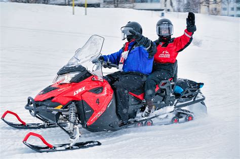 People On Snowmobile Waving Hand On Frozen Lake Rovaniemi Winter