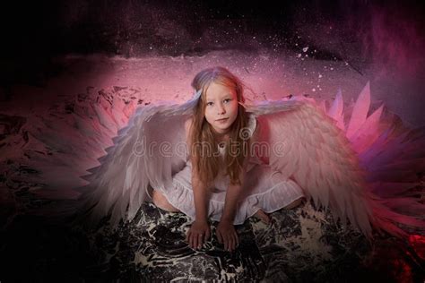 A Girl In A White Shirt Wings And With Long Hair Looking Like A Angel A Young Model Posing At