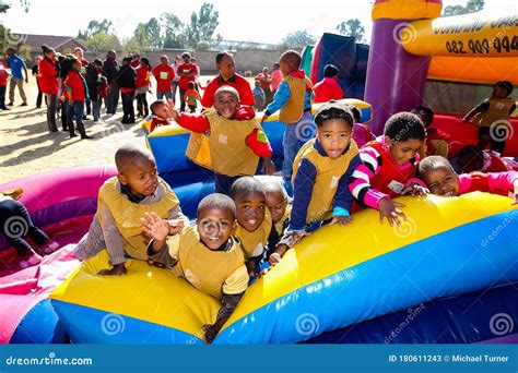 Young African Preschool Children Having Fun On A Jumping Castle On The