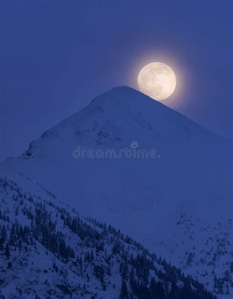 Full Moon Rising Behind A Snowy Mountain Stock Image Image Of