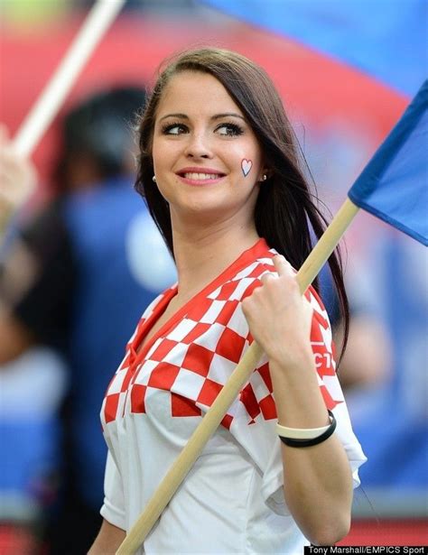 A Woman Holding A Blue And White Checkered Flag In Her Hand While Smiling At The Camera