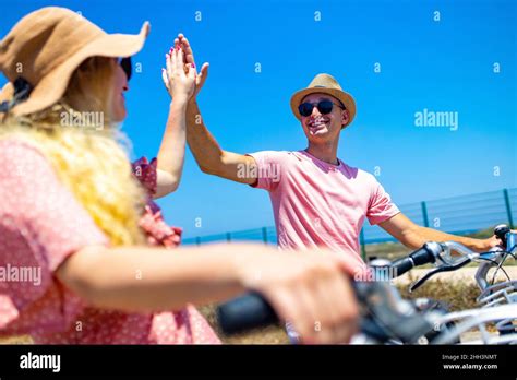 Happy Adult People Cheerful Couple Enjoy The Outdoor Leisure Activity Riding A Bike Seaside
