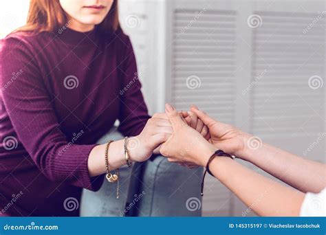Two Women Supporting Encouraging And Holding Hands Of Each Other Stock