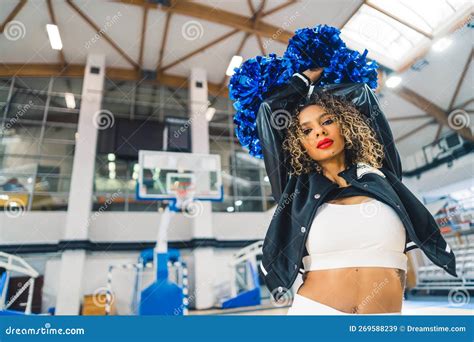 Confident Curly Haired Cheerleader Holding Pom Poms Up N Her Head