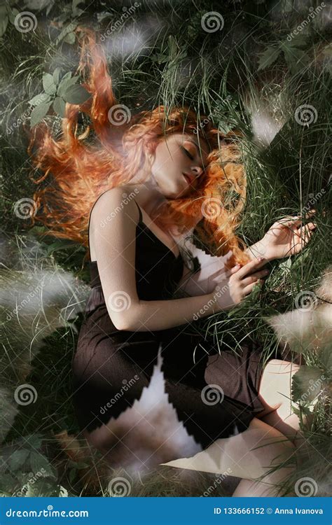 Romantic Woman With Red Hair Lying In The Grass In The Woods A Girl In A Light Black Dress