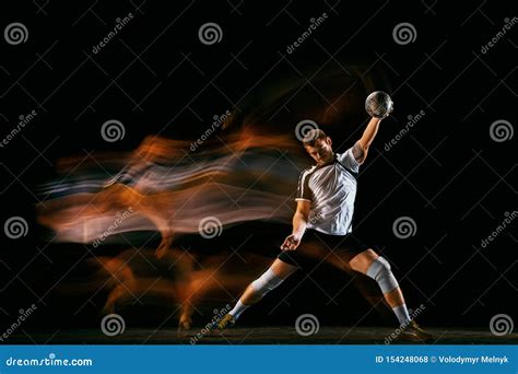 Young Handball Player Against Dark Studio Background In Mixed Light