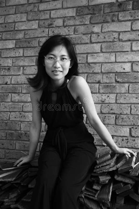 Beautiful Asian Woman Looking At The Viewer Sitting On Wooden Planks