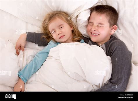 dos lindos niños durmiendo juntos compartiendo la misma cama con un niño pequeño exigen