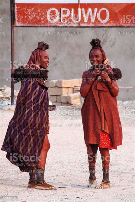 Himba Women With The Typical Necklace And Hairstyle In The Streets Of