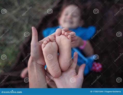 mom holds her little daughter `s feet white feet with gentle skin royalty free stock image
