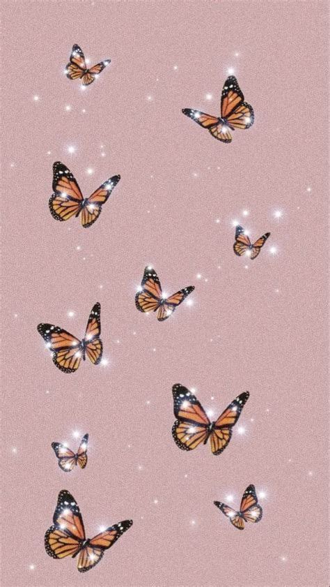 A Group Of Butterflies Flying Through The Air With Sparkles In The Sky
