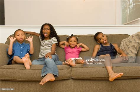 Four Siblings Sitting On Sofa Making Faces Portrait Photo Getty Images