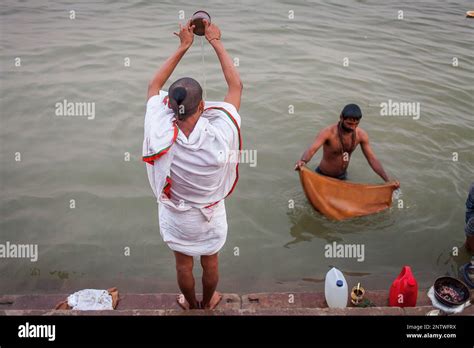 A Men Praying And Bathing In The Ghats Of Ganges River Varanasi Uttar Pradesh India Stock