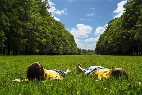 Children Lie On The Bright Green Grass And Smile Children S Day Stock