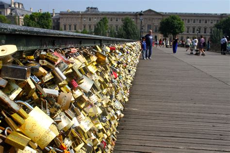 Many Padlocks Are Attached To The Fence With Locks On Them And People