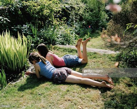 Two Girls Lying Down In A Garden Photo Getty Images