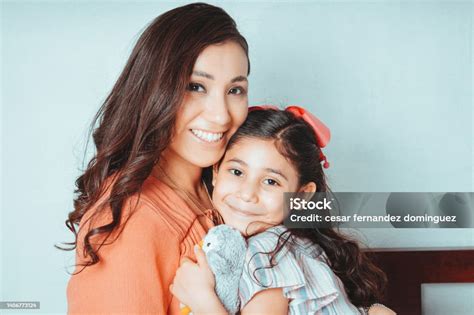 Feliz Mamá E Hija Mexicanas Abrazadas Mirando A La Cámara Foto De Stock