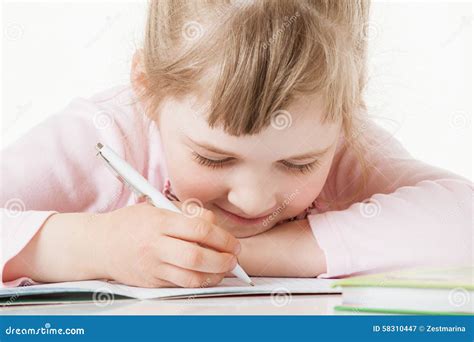 Menina Pequena Feliz Da Escola Que Aprende Escrever Imagem De Stock