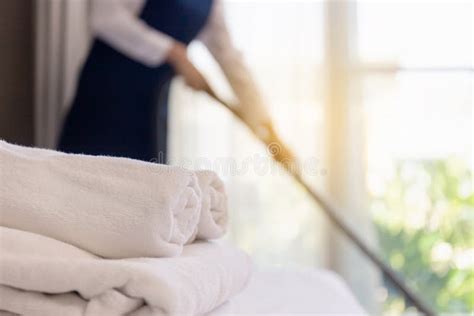 Clean Fresh Towels On The Bed With Blurred Room Service Maid Cleaning