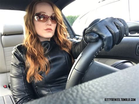 A Woman Sitting In The Drivers Seat Of A Car With Her Hands On The