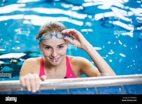 Female Swimmer In An Indoor Swimming Pool Looking At The Camera Smiling Wholeheartedly