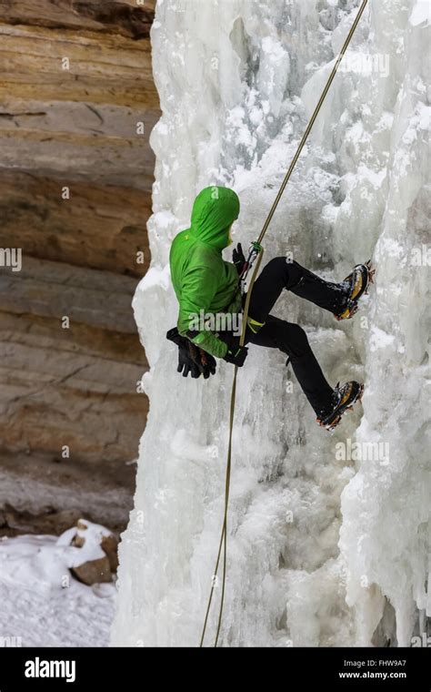 Ice Climber Rappelling Down A Frozen Waterfall In Pictured Rocks