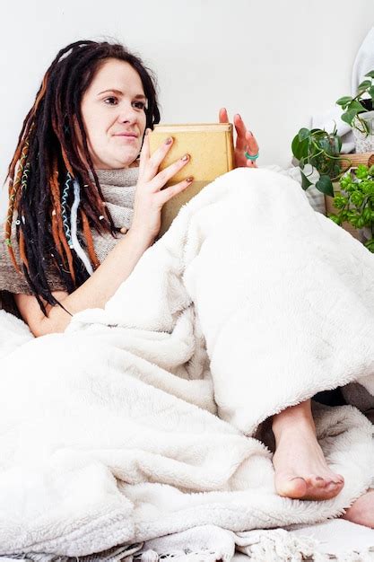 Premium Photo Woman Relaxing In Cozy Blankets Reading A Book In A