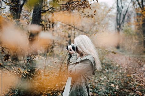 Blonde Woman Taking Picture With Camera In Nature By Stocksy