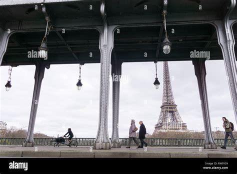 People Passing Along The Bir Hakeim Bridge With A View Of The Eiffel