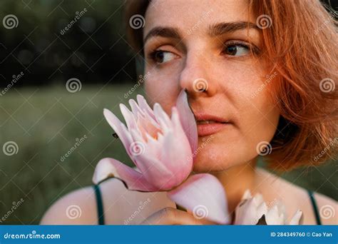 Beautiful Young Woman In Green Silk Evening Dress Holding Water Lily Flower Outdoors Stock