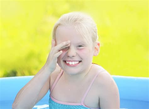 Premium Photo Little Blonde Girl Playing In Outdoor Swimming Pool On Hot Summer Day