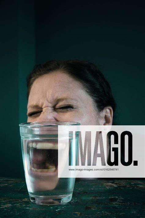 Wütendes Gesicht einer Frau gespiegelt in einem Wasserglas