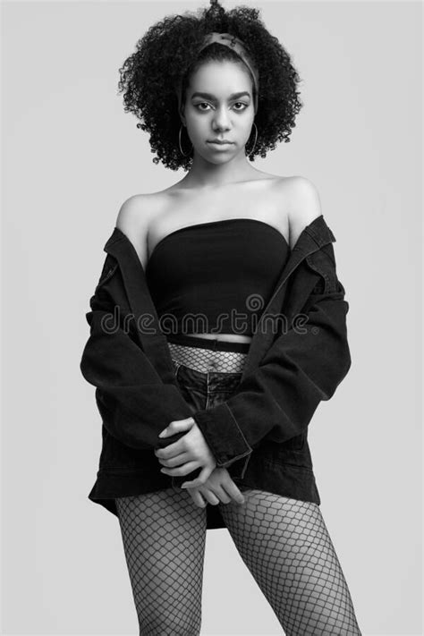 glamor elegant black hipster teenage model with curly hair in jeans shorts and stockings stock