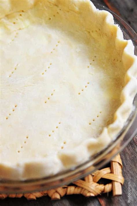 An Uncooked Pie Crust Sits In A Glass Dish On A Wooden Table Top