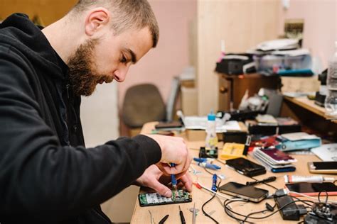 Premium Photo The Technician Repairing The Smartphone Motherboard In