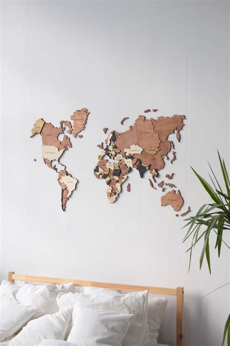 A Bedroom With A Bed And A Wooden World Map On The Wall