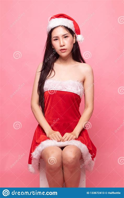 Het Portret Van Het Leuke Aziatische Meisje Van Kerstmissanta Claus Zit