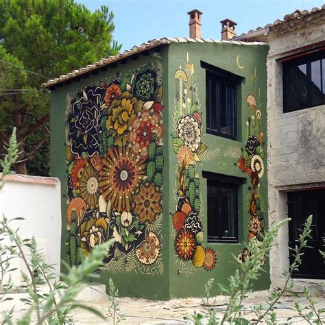 A Green Building With Flowers Painted On It