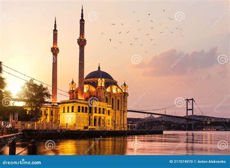 The Ortakoy Mosque And Bosphorus Bridge At Sunrise With Many Seagulls