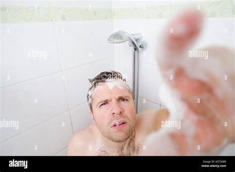 Un joven hombre caucásico toma una ducha y avisos una cámara oculta Fotografía de stock Alamy