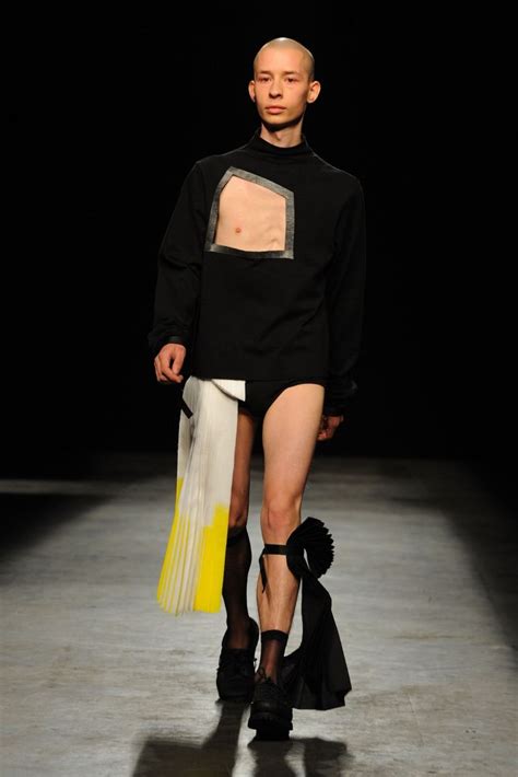 A Man In Black Shirt And Shorts Walking Down A Runway