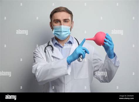 Doctor Holding Rubber Enema On Grey Background Stock Photo Alamy
