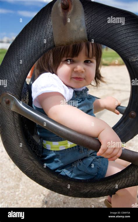 Girl Sitting In Tyre Swing At Playground Stock Photo Alamy