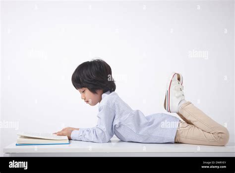A Kid Lying On The Floor Reading A Book Stock Photo Alamy