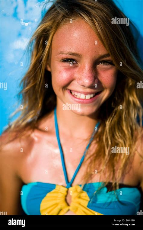 Cute Teenage Blond Girl Enjoys A Day At The Beach With Surf Board Stock