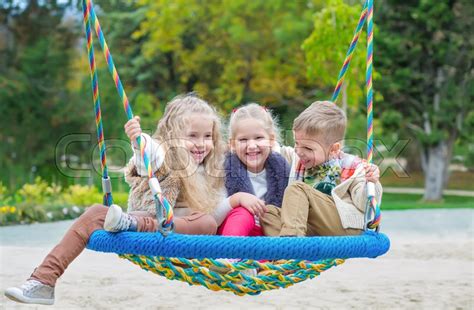 Three Children Playing In The Park With Stock Image Colourbox