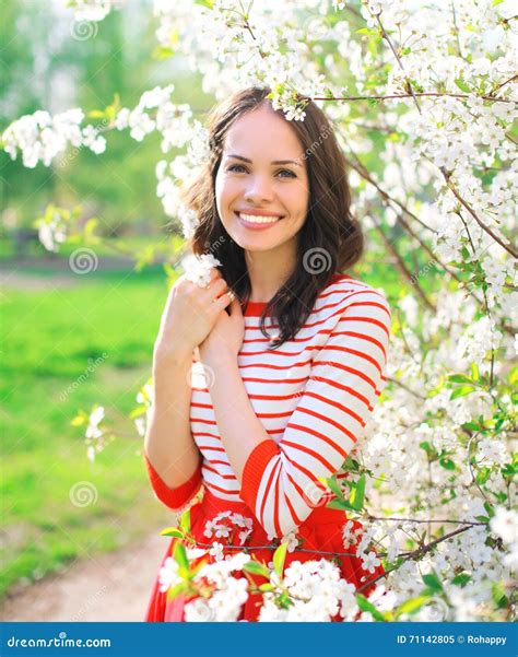 Portrait Of Beautiful Smiling Young Woman In Flowering Spring Garden