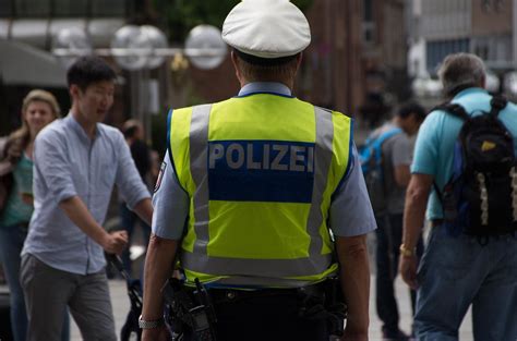Bokeh Photo Of German Police Officer In Yellow Vest Walking In A City Creative Commons Bilder